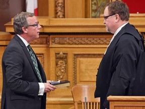 Saskatchewan Premier Brad Wall, left, with Greg Putz, right, Clerk of the Legislative Assembly during the swearing in ceremony at the Legislative building on Monday.