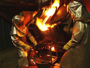Employees with Claude Resources prepare to pour some molten gold.