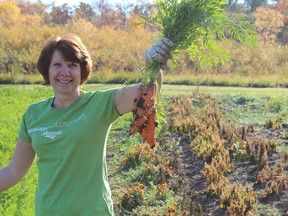 Mosaic Company’s­ Mary Langman, land and minerals associate from the Regina office, shows off some of the produce­ grown at the Community­ Food Farm in Moose Jaw.