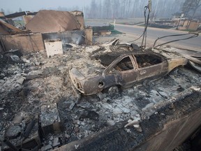 Home foundations and shells of vehicles are nearly all that remain in a residential neighborhood destroyed by a wildfire on May 6, 2016, in Fort McMurray.
