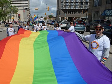 A large pride flag is carried down Broad St.  at the Queen City Pride Parade in Regina, Sask. on Saturday June. 25, 2016.