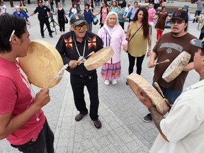 Archie Weenie (C) with the Sweetgrass First Nation along with the Open Sky Retreat drummers during a round dance celebrating National Aboriginal Day at City Square Plaza in Regina.