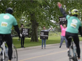 Avery Westberg, Kaitlyn Willner and Sara Hearn, from left, cheer on cyclists at a Ride Don't Hide fundraiser for mental health bike race that ended at the RCMP Heritage Centre in Regina, Sask. on Sunday June. 26, 2016. MICHAEL BELL