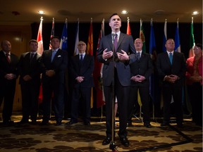 Federal Finance Minister Bill Morneau is flanked by his provincial and territorial counterparts in Vancouver on June 20 as he announces a deal to expand the Canada Pension Plan.