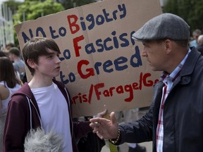 A demonstrator (L) holds a placard as he argues with a pedestrian during a protest against the pro-Brexit outcome of the UK's June 23 referendum on the European Union in London on June 25.