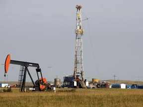 Pumpjack and drilling rig near Weyburn. The June sale of oil and gas drilling rights netted $3.9 million for the province, down 60 per cent from $9.8 million in June 2015 sale.