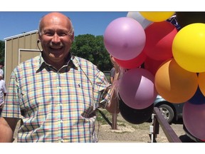 Chris Keyes, principal of George Lee School, holds a bundle of helium balloons used as a vessel to guide an egg safely to the ground, from 45 feet in the air, at the Great Egg Toss, on Friday.