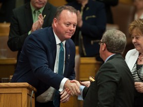 Saskatchewan Finance Minister Kevin Doherty shakes premier Brad Wall's hand after delivering the budget speech on June 1.