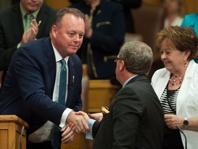 Saskatchewan Finance Minister Kevin Doherty shakes premier Brad Wall's hand after delivering the budget speech at the Legislative Building on June 1.