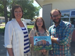 (L-R) Martine Noël-Maw, french translator, Judith Silverthorne, author, and Frédéric Dupré, president of les Éditions de la nouvelle plume, hold a copy of their newly launched bilingual edition of Hommage au Bison, in front of École Elsie Mironuck School, on Thursday.