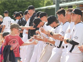 Members of the Fort McMurray Giants sign autographs for young fans following a game in Edmonton on May 29. The Giants have been playing their home games in Edmonton due to the wild fires in Fort McMurray. The Giants' first game in their home stadium is slated for Wednesday against the Regina Red Sox.