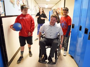Principal Dean Miezianko at Ethel Milliken Elementary School navigates around students Keon Anders and Alvy Chowdhury using a wheelchair. Spinal Cord Injury Saskatchewan Inc. hosted its Chair-Leaders "Enabling Access" Day on Wednesday, as community leaders like Miezianko raised awareness of working with limited mobility. DON HEALY / Regina Leader-Post