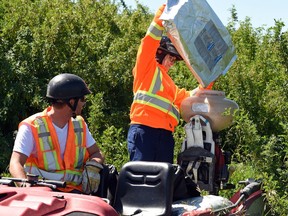 Burton Gerspacher (L) and Karina Harle both with the city of Regina Integrated pest management (IPM) unit fill up their sprayer with vectobac to combat mosquitoes in northwest Regina on June 24, 2016.