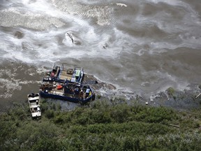 Crews work to clean up an oil spill on the North Saskatchewan river near Maidstone, Sask on Friday July 22, 2016. Husky Energy has said between 200,000 and 250,000 litres of crude oil and other material leaked into the river on Thursday from its pipeline.