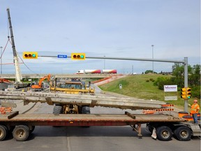 Road closed: A piece of the overpass is loaded onto a truck at Ring Road and Victoria Avenue in Regina on Saturday July 9.