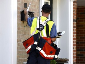 A postal worker delivers mail as an ongoing labour dispute between the Canadian Union of Postal Workers and Canada Post heated up Tuesday with the corporation issuing 72-hour lockout notice.