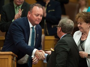 Saskatchewan Finance Minister Kevin Doherty shakes premier Brad Wall's hand after delivering the budget speech on June 1.