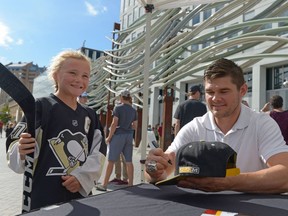 Elise Baron, left, gets her hockey stick autographed by Stanley Cup-winning Pittsburgh Penguins forward Chris Kunitz on Tuesday at City Square Plaza.