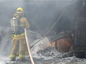 Firefighters contain a garage fire at 42 Fletcher Place in Regina, Sask. on Sunday July 31, 2016. MICHAEL BELL