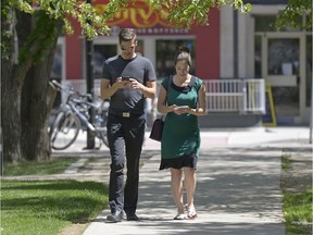 Jeff Reid and Alecia Perry play Pokemon Go on their handheld devices in Victoria Park in Regina, Sask. on Monday July 18, 2016.