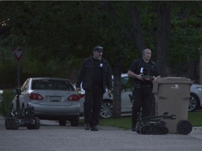Members of the Explosives Disposal Unit direct two robots during an investigation on Runciman Cres. in Regina, Sask. on Tuesday July 26, 2016.