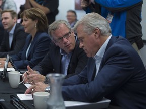 Newfoundland and Labrador Premier Dwight Ball, right, speaks with Saskatchewan Premier Brad Wall at the beginning of a meeting of premiers in Whitehorse, Yukon on Thursday.