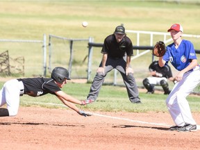 Nick Rein of Team Regina, left, dives toward first base as Melville's Garrett Houston, a member of the Parkland Valley team, accepts a throw on Monday in Saskatchewan Summer Games baseball action in Estevan.