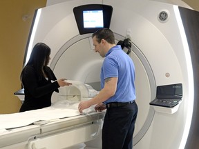 MRI Technologists Priya Kumar, left, and Kevin Johannson stand beside a 1.5 Tesla large bore MRI machine at Mayfair Diagnostics in Regina.