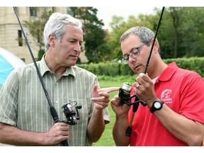 Jason Matity (R), Learn to Fish instructor and Mark Docherty (L), Saskatchewan minister of parks, culture and recreation discuss fishing rod technique during a learn to camp and fish programs news conference on Monday in Regina.