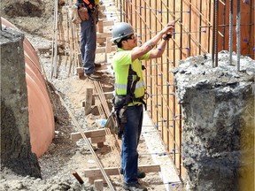 Construction crews tie rebar at the site of Silver Sage Housing's 24-unit affordable rental suites for families.  The total cost of the project is approximately $5.5 million. Construction jobs were hard hit in June, with 8,200 fewer jobs than in June 2015, according to Statistics Canada's labour force report Friday.