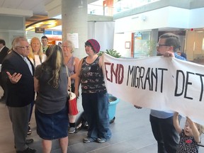 Federal Public Safety Minister Ralph Goodale (left) talks with protesters concerned about the government's continued detention of arrivals whose identities cannot be confirmed or who are deemed a flight risk or security threat.