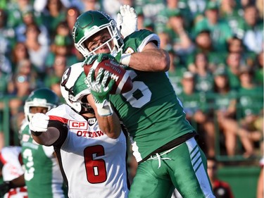 Saskatchewan Roughriders defensive back Rob Bagg makes a catch under pressure from Ottawa Redblacks defensive back Antoine Pruneau during CFL action at Mosaic Stadium in Regina.