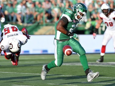 Saskatchewan Roughriders running back Curtis Steele runs for the ball as Ottawa Redblacks linebacker Damaso Munoz trips on the play during CFL action against the Ottawa Redblacks at Mosaic Stadium in Regina.