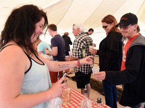 Shelby Moorby (L) serves up dill pickle vodka to Roger Wirth (R) of Weyburn during Caesar Fest at Last Mountain Distillery in Lumsden. Activities included Caesar Gardens and Caesar Olympics and the launch of Bacon Vodka.  DON HEALY / Regina Leader-Post