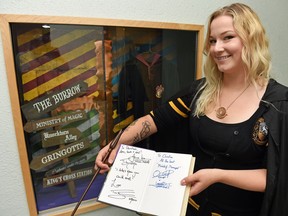 Harry Potter fan Christina Arsenault shows off her Harry Potter autographs in front of the Harry Potter Display at the Sherwood Village Library in Regina.  This weekend is the release of the new Harry potter book Harry Potter and the Cursed Child.