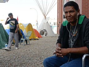Robbin Whitecap, left, walks while Prescott Demas looks on at Colonialism No More Solidarity Camp outside of the Indigenous and Northern Affairs Canada office in Regina.