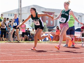 Tatiana Dutka of Bienfait, left, accepts the baton from Brynna Spence of Weyburn as the South East team competes in a relay Wednesday at the Saskatchewan Summer Games in Estevan.