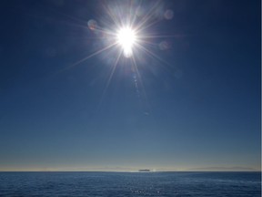 A container cargo vessel is seen under the midday sun on the horizon crossing the Pacific Ocean. The world's oceans are warming but debate rages over the cause.