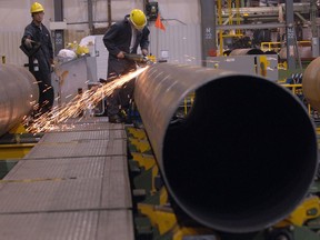Evraz employees work on pipe in the $90-million expansion at Evraz NA Inc. in 2008. Evraz confirmed 125 pipe mill workers will be laid off  Aug. 7, 2016.