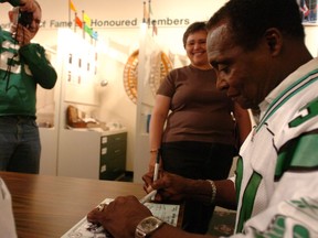 Legendary Saskatchewan Roughriders fullback George Reed is shown signing autographs at the Saskatchewan Sports Hall of Fame in 2006 during a 40th-anniversary reunion of the 1966 championship team. Reed and his teammates will also be at the Hall on Saturday when the 50th anniversary is celebrated.
