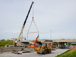 Workers dismantle the overpass piece by piece at the Ring Road and Victoria Avenue in Regina on July 9, 2016.