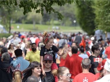 Zoey Cantin waves while on the shoulders of Josh Mock during Canada Day celebrations near the Legislative Building in Regina, Sask. on Friday July 1, 2016. MICHAEL BELL