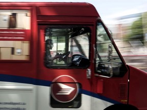 A Canada Post employee drives a mail truck through downtown Halifax on July 6.