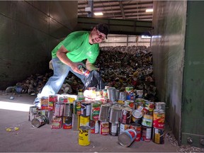 Dale Gross sifts through cans at the Emterra Waste Management and Recycling centre to find cans for the Nature Conservancy of Canada bird conservation project at Old Man on His Back Prairie and Heritage Conservation Area.