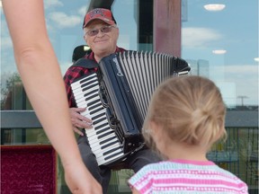 Dan "The Accordian Man" Petrie smiles while playing outside the Quance Street liquor store in Regina, Sask. on Sunday.