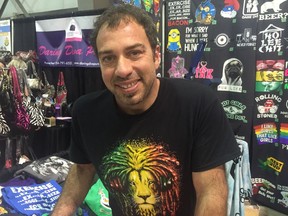 Francesco Minniti, owner of Ocean Magma Designs, stands in his t-shirt booth at the Queen City Ex inside of the Co-operator's Centre, on Friday.