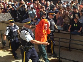 Gerald Stanley, hooded, is escorted past a gauntlet of media and Colten Boushie's supporters.