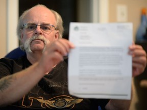 Brad Cavanagh looks a letter from the Saskatchewan Assured Income for Disability (SAID) Program in Regina on Friday.  The letter explains some recent funding cuts to recipients on SAID.