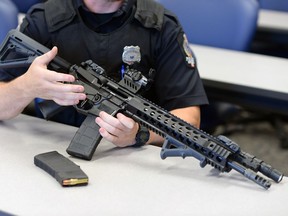 Regina Police Service   Armourer Const. Rick Bosche points out some of the features on this disabled demonstration AR-15 carbine rifle at the Regina police headquarters.  This demonstration rifle is not the exact model the RPS will receive but is a very close representation of the model that will be going into service.