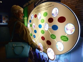 Nancy Martin, of Ottawa, checks out the exhibits in the Together Truck parked at the Farmers Market on City Square Plaza on Wednesday.  The vehicle, travelling across Canada, is an exhibition to promote the fight against poverty -- featuring powerful photography, film, audio and artefacts.